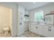 Laundry room features white cabinets, a sink, and a window for natural light and ventilation at 4901 Prince Se Rd, Smyrna, GA 30082
