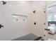 Walk-in shower with white tile, black hardware, a tiled niche, and a black tiled floor at 4901 Prince Se Rd, Smyrna, GA 30082