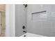 Shower with gray subway tile, black hardware, a built-in niche, and a white tub at 4901 Prince Se Rd, Smyrna, GA 30082