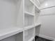 Walk-in closet features built-in white shelving, rod for hanging, and modern tile flooring at 4901 Prince Se Rd, Smyrna, GA 30082