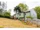 Green home with a well-maintained backyard, featuring a spacious deck and lush greenery at 114 Summer Glen Pl, Dallas, GA 30157