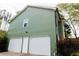 Side view of a green home featuring a two-car garage and a white door at 114 Summer Glen Pl, Dallas, GA 30157