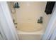 A soaking tub with tile surround and chrome fixtures is ready to enjoy with privacy curtains at 1575 Kilmington Ct, Alpharetta, GA 30009