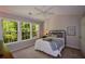 A well-lit bedroom features carpet, a ceiling fan, and a large window with views of the outdoors at 1575 Kilmington Ct, Alpharetta, GA 30009