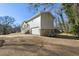 View of a two-story home featuring a stone and vinyl exterior, attached garage, and ample driveway space at 1721 Hortense Nw Pl, Atlanta, GA 30318