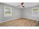 Bright bedroom with fresh paint, wood-look flooring, two windows, and modern ceiling fan at 46 Forkwood Cir, Hiram, GA 30141