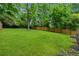 Expansive lawn, mature trees and landscaping, and a wood privacy fence at 2590 Eastwood Dr, Decatur, GA 30032