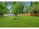 Spacious backyard features lush lawn, mature trees, firepit, and new wood fence at 2590 Eastwood Dr, Decatur, GA 30032