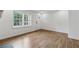 Light-filled living room with hardwood floors, large windows overlooking the front yard, and white walls at 2590 Eastwood Dr, Decatur, GA 30032
