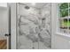 Shower with marble-look tile, rain shower head, and glass enclosure at 2590 Eastwood Dr, Decatur, GA 30032