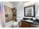 A bathroom featuring a bath and shower, tile surround and modern fixtures at 3253 Cates Ne Ave, Brookhaven, GA 30319