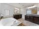 A bathroom featuring double sinks, tile flooring, a drop-in bathtub and walk-in shower at 3253 Cates Ne Ave, Brookhaven, GA 30319