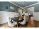 Elegant dining room featuring wainscoting, a modern chandelier, and a large wooden table at 3253 Cates Ne Ave, Brookhaven, GA 30319