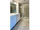 Bathroom featuring double sink vanity, white cabinets, and glass enclosed shower at 3658 Hidden Valley Cir, Lawrenceville, GA 30044
