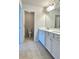 Well-lit bathroom with double sink vanity, white cabinets, and tile floor at 3658 Hidden Valley Cir, Lawrenceville, GA 30044
