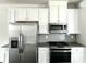 Kitchen exhibiting granite countertops, stainless steel appliances, grey backsplash, and hardwood floors at 3658 Hidden Valley Cir, Lawrenceville, GA 30044
