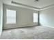 Carpeted main bedroom with tray ceiling and two large windows at 3658 Hidden Valley Cir, Lawrenceville, GA 30044