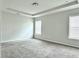 Bright carpeted main bedroom features a tray ceiling and two large windows at 3658 Hidden Valley Cir, Lawrenceville, GA 30044