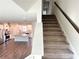 Carpeted stairs in an open floor plan leading to an upstairs bedroom, near a modern kitchen at 3658 Hidden Valley Cir, Lawrenceville, GA 30044