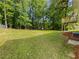 Spacious backyard with lush green grass and mature trees offering privacy and shade at 6735 Smoke Ridge Dr, Atlanta, GA 30349