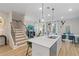 Bright open concept kitchen with island and seating, flowing into a stylish living area with modern staircase at 186 Abbotts Crossing Cir, Conyers, GA 30094