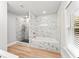 Modern bathroom featuring a shower, tub, and marble tiled walls with gold accents at 2128 Hosea L Williams Ne Dr, Atlanta, GA 30317