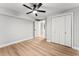 Bedroom featuring light gray walls, light wood floors, ceiling fan, and double door closet at 2128 Hosea L Williams Ne Dr, Atlanta, GA 30317