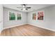 Bedroom featuring light gray walls, light wood floors, two windows, and ceiling fan at 2128 Hosea L Williams Ne Dr, Atlanta, GA 30317