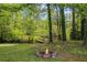 Relaxing backyard featuring a fire pit and a serene creek with a wooden bridge at 3717 Birchbriar Ct, Decatur, GA 30034