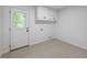 Functional laundry room featuring tiled floors, built-in cabinets, and a convenient exterior door at 3717 Birchbriar Ct, Decatur, GA 30034
