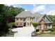 Charming two-story home with a brick and stone facade, manicured landscaping, and a spacious driveway at 4231 Shamans Dr, Marietta, GA 30062