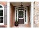 Elegant front entrance featuring a dark wood door, white columns, and lush landscaping at 4231 Shamans Dr, Marietta, GA 30062