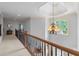 Elegant hallway featuring hardwood railing, soft carpet, and decorative chandelier over looking a large window at 4231 Shamans Dr, Marietta, GA 30062
