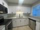 Well-lit kitchen featuring modern stainless steel appliances, white cabinets, and granite countertops at 122 Maison Nw Pl, Atlanta, GA 30327