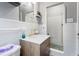 Updated bathroom with white tiles, modern vanity, gold faucet, and glass-door shower at 1496 S Hairston Rd, Stone Mountain, GA 30088
