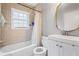 Cozy bathroom featuring shower-tub combo, window, standard toilet, and pedestal sink at 1496 S Hairston Rd, Stone Mountain, GA 30088