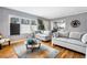 Bright living room with hardwood floors, a large window, and gray couches at 1496 S Hairston Rd, Stone Mountain, GA 30088