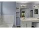 Bright bathroom featuring double sinks, large mirror with vanity lighting, and tiled backsplash at 2455 Kirkstone Dr, Buford, GA 30519