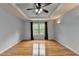 Spacious bedroom with hardwood floors, tray ceiling, and large window offering natural light at 2455 Kirkstone Dr, Buford, GA 30519