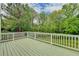 Relaxing deck with white railing, offering stunning views of the landscaped backyard and lush greenery at 2455 Kirkstone Dr, Buford, GA 30519