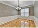 Dining room featuring beautiful crown molding, wainscoting, chandelier, and wood floors at 2455 Kirkstone Dr, Buford, GA 30519