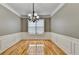 Dining room featuring beautiful crown molding, wainscoting, chandelier, and wood floors at 2455 Kirkstone Dr, Buford, GA 30519