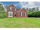 Charming two-story brick home on a lush green lawn features black shutters and a bay window at 2455 Kirkstone Dr, Buford, GA 30519