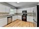 Well-equipped kitchen featuring stainless steel appliances, granite countertops, and beautiful wood floors at 2455 Kirkstone Dr, Buford, GA 30519