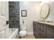 Elegant bathroom featuring gray tiling, modern fixtures, and an oval mirror at 354 Tarragon Sw Way, Atlanta, GA 30331