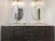Bathroom vanity with double sinks, granite countertop, and oval gold-trimmed mirrors at 354 Tarragon Sw Way, Atlanta, GA 30331