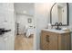 Charming bathroom featuring a modern vanity, and an open doorway into the bedroom with hardwood floors at 354 Tarragon Sw Way, Atlanta, GA 30331