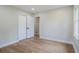 Cozy bedroom with wood-look flooring, closet, and a window providing natural light at 354 Tarragon Sw Way, Atlanta, GA 30331