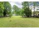 Expansive back yard surrounded by mature trees offering privacy and space for outdoor activities and potential landscaping at 3884 Vic Ar Ct, Peachtree Corners, GA 30360