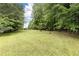 Lush green backyard with mature trees creating a peaceful and private outdoor space, perfect for recreation and relaxation at 3884 Vic Ar Ct, Peachtree Corners, GA 30360